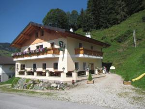 a house with a balcony on the side of a hill at Appartement Grubbauer in Wagrain +16 photos