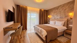 ein Hotelzimmer mit Bett, Schreibtisch und Fenster in der Unterkunft Pensiunea ROCA Maramures in Deseşti