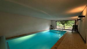 a large swimming pool with blue water in a room at Ferienwohnung mit eigenem Pool und finnischer Sauna in Witten in Witten