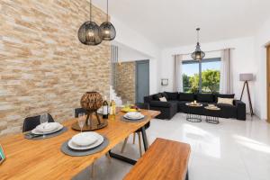 a living room with a wooden table and a brick wall at Villa Livis 1 in Kiotari