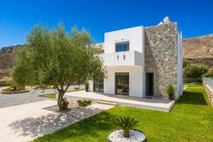 a white house with a tree in front of it at Villa Livis 1 in Kiotari