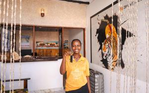 a boy standing in a room with a picture of a tiger at Zenobia Beach Resort in Nungwi