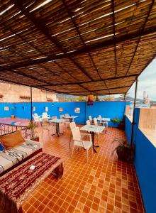 a patio with tables and chairs and blue walls at Hostel Znika Chefchaouen in Chefchaouen +21 photos