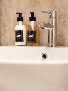 two bottles of soap sitting on a bathroom sink at Looking for long term rentals; huge discount. Caithness. in Lybster