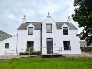 a white house with a green lawn at Looking for long term rentals; huge discount. Caithness. in Lybster