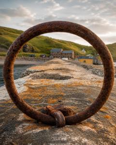 an old rusty ring on a rock near the water at Looking for long term rentals; huge discount. Caithness. in Lybster