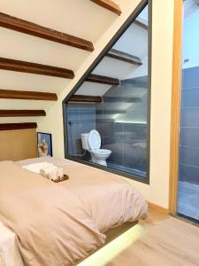 a bedroom with a large window with a toilet at Saimer Home in Tân Thành (1)