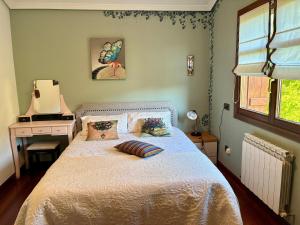 a bedroom with a bed with a white bedspread and a desk at Caserio Arrigorri in Murguía