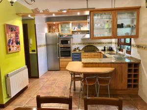 a kitchen with a table and a refrigerator at Caserio Arrigorri in Murguía +18 photos