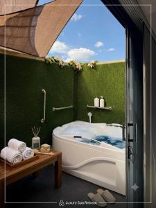 a bath tub in a bathroom with a window at Laureles Premium Loft con Jacuzzi Privado in Medellín +91 photos