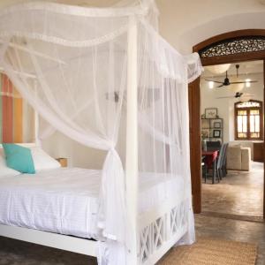 a bedroom with a white bed with a canopy at Agwe Villa - Hikkaduwa in Dodanduwa +48 photos