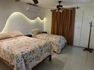 a bedroom with two beds and a ceiling fan at Victory House Mty in Monterrey
