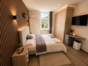 a bedroom with a large bed and a television at Kurvilla Hotel & Apartment in Landstuhl