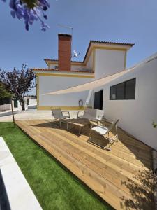 ein Hinterhof mit Holzterrasse und einem Haus in der Unterkunft CasaSoldoré in Sesimbra