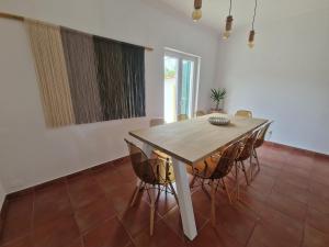 ein Esszimmer mit einem Holztisch und Stühlen in der Unterkunft CasaSoldoré in Sesimbra