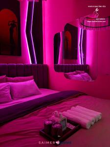 a pink room with two beds with pink lighting at Saimer Home in Tân Thành (1)