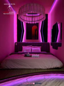 a bedroom with a bed with pink lighting at Saimer Home in Tân Thành (1) +2 photos