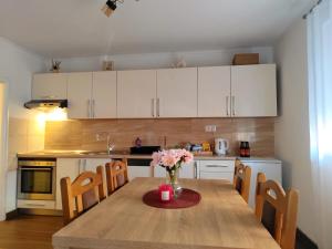 a kitchen with a wooden table with a vase of flowers on it at Apartman Dream in Livno