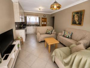a living room with two couches and a tv at Galago Rest in Leeupoort