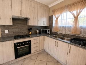a kitchen with wooden cabinets and a sink and a stove at Galago Rest in Leeupoort