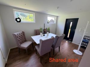 a dining room with a white table and chairs at Panoramic Room with Sea View in Hundsnes +2 photos