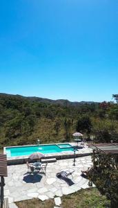 a large swimming pool with umbrellas and chairs at Chalé aconchegante, pertinho da cidade e conectada a natureza in Brasília
