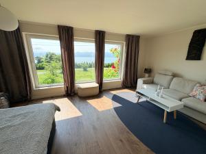 a living room with a couch and large windows at Panoramic Room with Sea View in Hundsnes