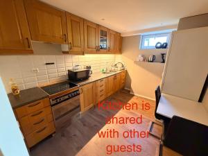 a kitchen with wooden cabinets and a white refrigerator at Panoramic Room with Sea View in Hundsnes