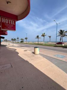an empty street with a hotel sign and palm trees at Hotelito Fiesta Caribena in Coatzacoalcos