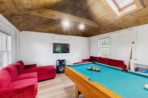 a living room with a pool table and red couches at Pond Treasure in Sandwich