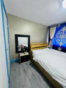 a bedroom with a large bed and a mirror at Unique private rooms (1) in Bolton