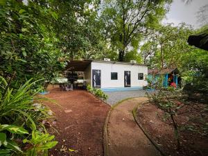 a small white house in the middle of a yard at Bela Blue Stays in Bardez