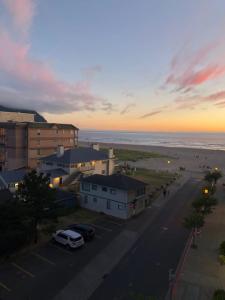 a city street with buildings and a beach at sunset at Seaside Ocean Front Condo in Seaside