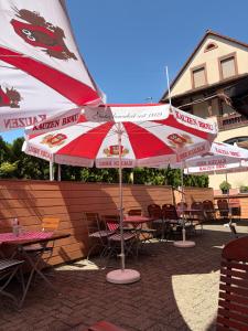 a group of tables and chairs with umbrellas at Gasthaus Goldener Anker in Gemünden +25 photos
