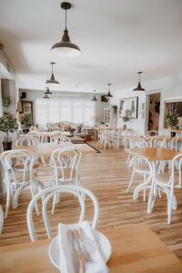a room with white tables and white chairs at The Beach House in West Wittering +39 photos
