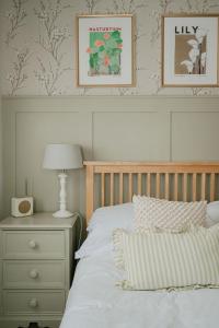 a bedroom with a bed and a nightstand with a lamp at The Beach House in West Wittering
