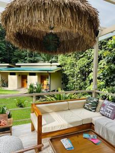 a living room with a couch under a straw umbrella at Fauna Lodge in Drake