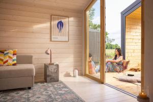a woman sitting in a chair on the porch of a house at 110 Tiny House mit traumhaftem Blick über die Wiese in Bleckede