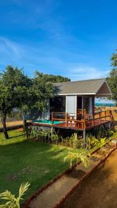 a house with a deck with a table and chairs at Leopard Inn Arugam Bay in Arugam Bay