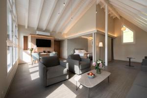 a living room with a couch and chairs and a bed at Hotel Safiro in Fluelen