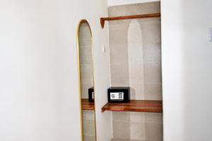 a bathroom with a mirror and a clock on a shelf at The lagoons resort Zanzibar in Nungwi