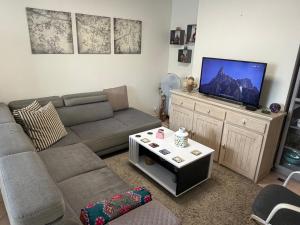 a living room with a couch and a flat screen tv at Chez-Sonia chambre 1 in Rosny-sous-Bois