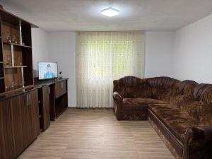 a living room with a leather couch and a television at Casa David in Mălăeşti