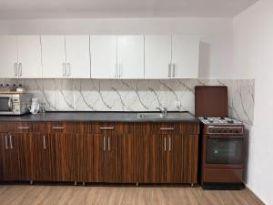 a kitchen with wooden cabinets and a stove top oven at Casa David in Mălăeşti