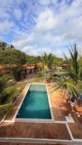 a person standing next to a swimming pool at Pousada Bouganvile Atins in Atins