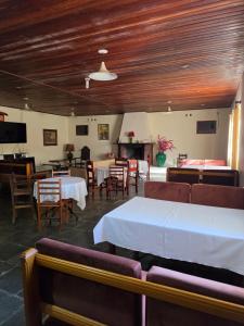 a dining room with tables and chairs and a fireplace at Big Valley Hotel Fazenda in Serra Negra