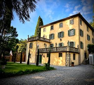 a large yellow building with a balcony at Villa Amore Tuscany in Capannori