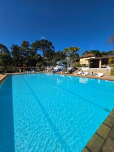 a large swimming pool with blue water at Big Valley Hotel Fazenda in Serra Negra
