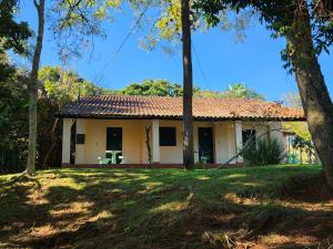 a house in the middle of a yard with trees at Big Valley Hotel Fazenda in Serra Negra