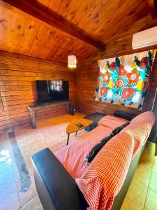 a living room with a couch and a flat screen tv at Fuente del Lobo Glamping & Bungalows - Adults Only in Pinos Genil